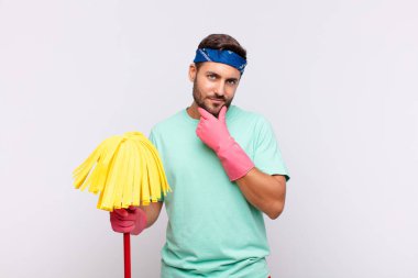 Genç adam ciddi görünüyor, düşünceli ve güvensiz, bir kolu çapraz ve çene üzerinde, seçenekleri tartıyor