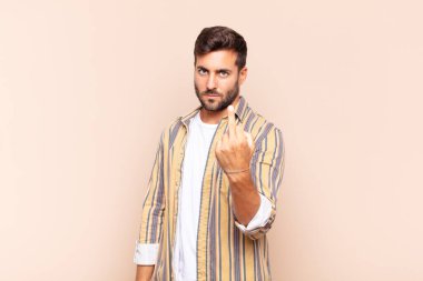 Genç adam kızgın, sinirli, asi ve agresif hissediyor, orta parmağını hareket ettiriyor, karşı koyuyor.