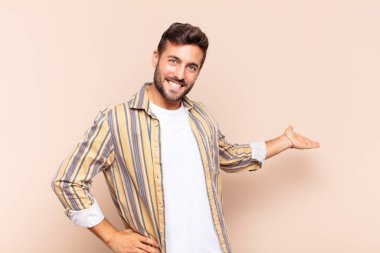 Genç adam kendini mutlu ve neşeli hissediyor, gülümsüyor ve seni hoş karşılıyor, seni dostça bir jestle içeri davet ediyor.