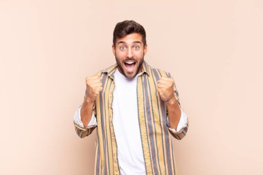 Genç adam şoke olmuş, heyecanlı ve mutlu, gülüyor ve başarıyı kutluyor,!