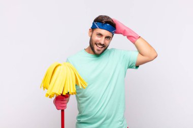 Genç adam neşeli ve sıradan bir şekilde gülümsüyor, olumlu, mutlu ve kendinden emin bir bakışla göğüs göğüse geliyor.