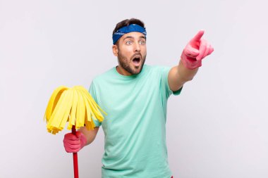 Genç adam şaşkın ve şaşırmış hissediyor, şaşırmış ve hayranlıkla yukarı bakıyor, şaşkın, açık ağızlı bir bakışla