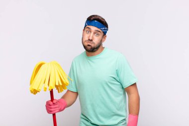 Genç adam şapşal, çılgın, şaşırmış bir ifadeyle, yanakları şişmiş, doldurulmuş, şişman ve yemekle dolu