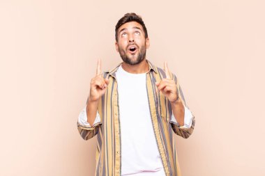 Delikanlı korkuyla ve ağzı açık bir şekilde şaşkın ve şaşkın bir bakışla yukarıya bakıyor.