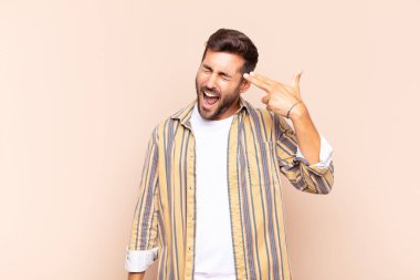 Genç adam mutsuz ve stresli görünüyor, intihar jesti elle silah işareti yapıyor, kafasını işaret ediyor.