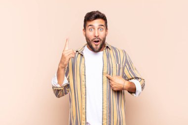 Genç adam gururlu ve şaşırmış hissediyor, kendine güvenen, başarılı bir numara gibi hisseden.