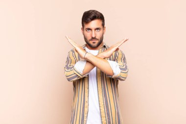 Genç adam senin bu tavırlarından rahatsız ve bıkkın görünüyor, yeter artık! Eller önde çapraz, durmanı söylüyor.