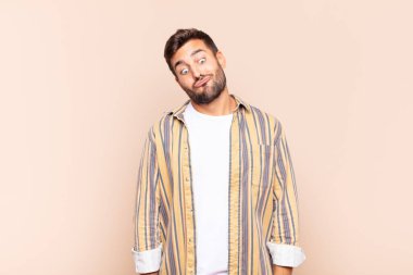 Genç adam şapşal ve komik görünüyor. Şaşı bakışlı, şakacı ve şakacı.