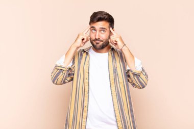 Genç adam odaklanmış ve bir fikir üzerinde kafa yoruyor, bir meydan okumaya veya soruna bir çözüm hayal ediyor.