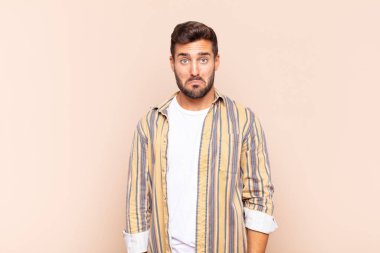 Genç adam üzgün ve stresli, kötü bir sürpriz yüzünden üzgün, olumsuz, endişeli bir bakışla