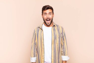 Delikanlı korkmuş ve şok olmuş hissediyor, ağzı açık ve şaşırmış.