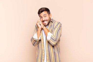 Genç adam aşık ve sevimli görünüyor. Sevimli ve mutlu. Romantik bir şekilde gülümsüyor.