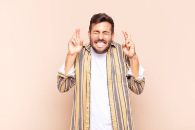 Genç adam gergin ve umutlu, şans diliyor ve dua ediyor.