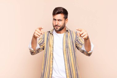 Genç adam kameraya hem parmaklarıyla hem de kızgın bir ifadeyle sana görevini yapmanı söylüyor.