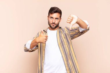 Genç adam kendini kafası karışmış, bilgisiz ve kararsız hissediyor. İyi ve kötü seçenekleri farklı seçeneklerle tartıyor.