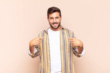 Genç adam gururlu, pozitif ve iki eliyle göğsünü gösteren