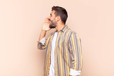 Genç adam profil görüntüsü, mutlu ve heyecanlı görünüyor, bağırıyor ve kenardaki boşluğu kopyalamak için arıyor