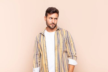 Genç adam üzgün, üzgün ya da kızgın ve olumsuz bir tavırla, anlaşmazlık içinde somurtuyor.