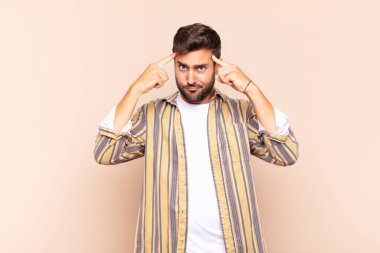 Ciddi ve yoğun bakışlı genç bir adam, beyin fırtınası yapıyor ve zorlu bir sorunu düşünüyor.