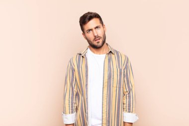 young man feeling puzzled and confused, with a dumb, stunned expression looking at something unexpected