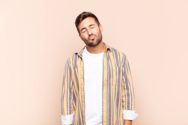 Genç adam dudaklarını birbirine bastırıyor, tatlı, eğlenceli, mutlu, sevimli bir yüz ifadesiyle, öpücük yolluyor.