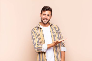 Genç adam neşeyle gülümsüyor, mutlu hissediyor ve bir konsepti fotokopi uzayında el ele vererek gösteriyor.