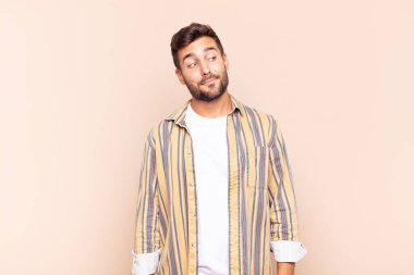 Genç adam merak ediyor, mutlu düşünceler ve fikirler düşünüyor, hayal kuruyor, kenarda yer arıyor.