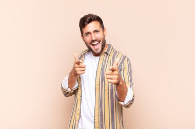 Genç adam kendini mutlu, sakin, tatmin olmuş, rahat ve başarılı hissediyor, kameraya bakıyor, seni seçiyor.