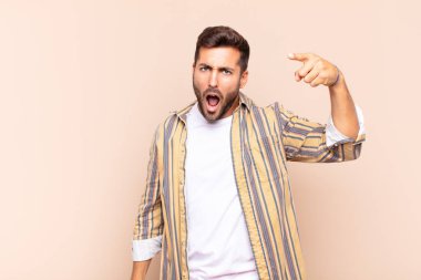 Öfkeli agresif bir ifadeyle kameraya bakan genç bir adam öfkeli, çılgın bir patron gibi görünüyor.