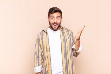 Genç adam mutlu, şaşırmış ve neşeli hissediyor, pozitif bir tavırla gülümsüyor, bir çözüm ya da fikir buluyor.