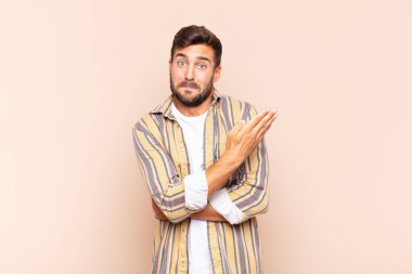 Genç adam kafası karışık ve bilgisiz, şüpheli bir açıklama ya da düşünceyi merak ediyor.