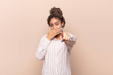 Genç afro kadın sana gülüyor, kamerayı gösteriyor ve seninle dalga geçiyor ya da alay ediyor.