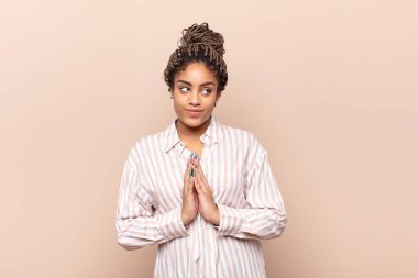 Genç afro kadın gururlu, haylaz ve kibirli. Şeytani bir plan kurarken ya da bir numara düşünürken.