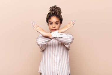 Genç afro kadın senin tavırlarından rahatsız ve bıkkın görünüyor, yeter artık! Eller önde çapraz, durmanı söylüyor.