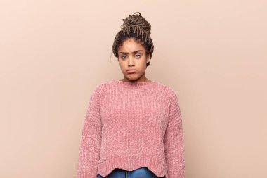 Genç afro kadın gülüyor, mutlu, pozitif ve şaşırmış görünüyor, yanal fotokopi alanını işaret eden harika bir fikri fark ediyor.