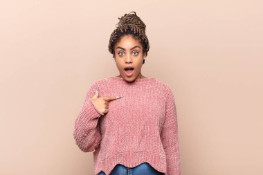 Genç afro kadın korkmuş ya da utanmış hissediyordu. Gözleri yarı kapalı ya da elleri kapalı dikizliyordu.