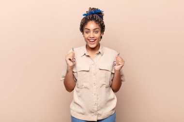 Genç afro kadın şaşkın, heyecanlı ve mutlu hissediyor, gülüyor ve başarıyı kutluyor,!