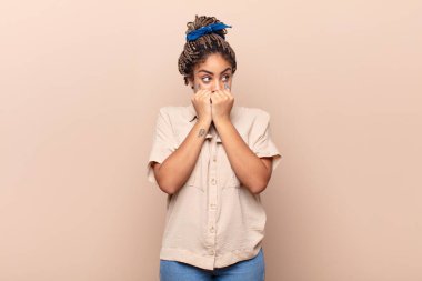 Genç afro kadın endişeli, stresli ve korkmuş görünüyor, tırnak yiyor ve yanal fotokopi alanı arıyor.