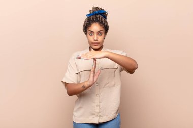 Genç afro kadın ciddi, sert, kızgın ve canı sıkkın görünüyor.