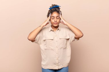 Genç afro kadın konsantre, düşünceli ve ilham verici görünüyor, beyin fırtınası yapıyor ve hayal kuruyor.