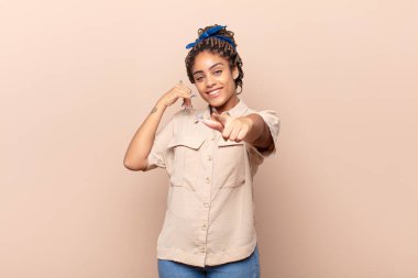 Genç afro kadın neşeyle gülümsüyor ve kamerayı işaret ediyor. Sonra seni arıyor, telefonla konuşuyor.