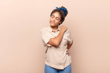 Genç afro kadın yorgun, stresli, endişeli, hayal kırıklığına uğramış ve depresyonda, sırtı ya da boynu ağrıyan