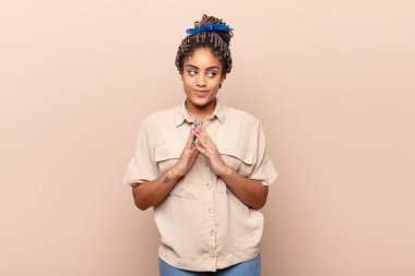 Genç afro kadın gururlu, haylaz ve kibirli. Şeytani bir plan kurarken ya da bir numara düşünürken.