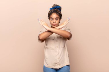 Genç afro kadın senin tavırlarından rahatsız ve bıkkın görünüyor, yeter artık! Eller önde çapraz, durmanı söylüyor.