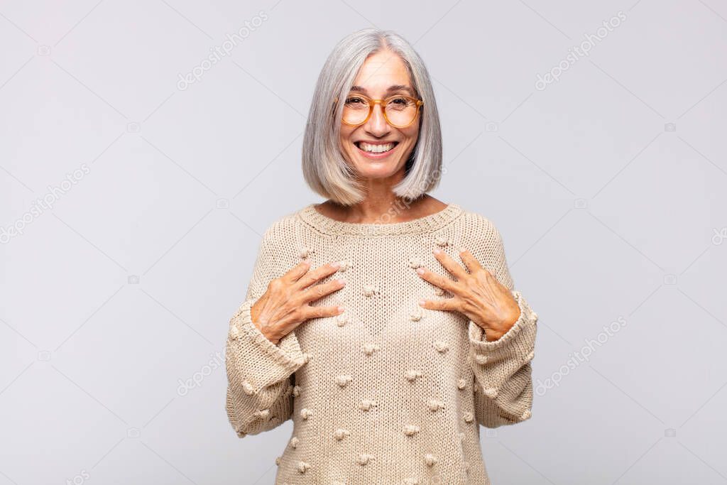 gray haired woman looking happy, surprised, proud and excited, pointing to self