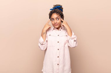 Genç afro kadın konsantre olmuş ve bir fikir üzerinde kafa yoruyor, bir soruna ya da soruna bir çözüm hayal ediyor.