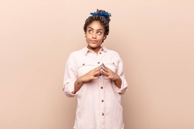 Genç afro kadın entrikalar ve komplolar kuruyor, sinsi hileler ve hileler düşünüyor, kurnazlık ve ihanet