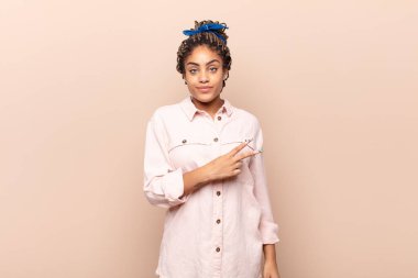 Genç afro kadın mutlu, pozitif ve başarılı hissediyor, göğsünde el yapımı V ile, zafer ya da barış gösteriyor.