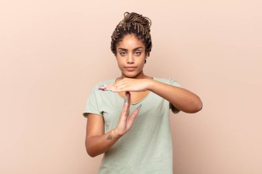 Genç afro kadın ciddi, sert, kızgın ve canı sıkkın görünüyor.