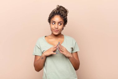 Genç afro kadın gururlu, haylaz ve kibirli. Şeytani bir plan kurarken ya da bir numara düşünürken.